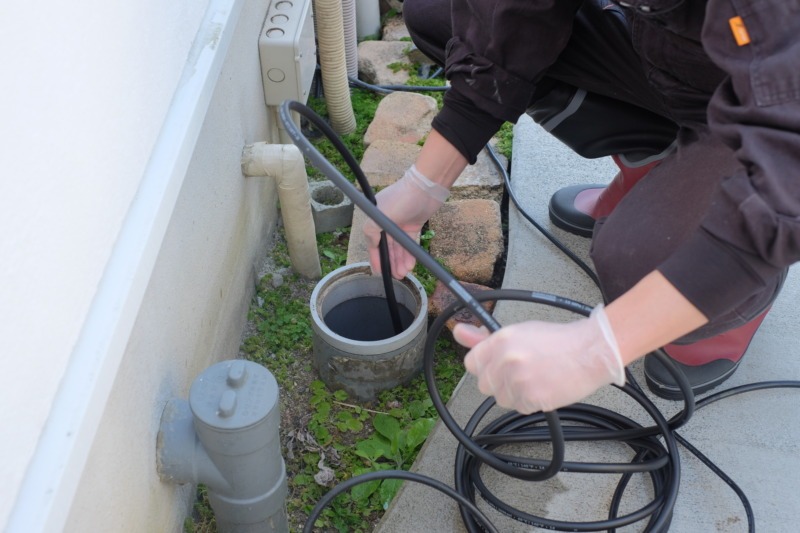 屋外の排水溝から高圧洗浄機を使って排水管洗浄